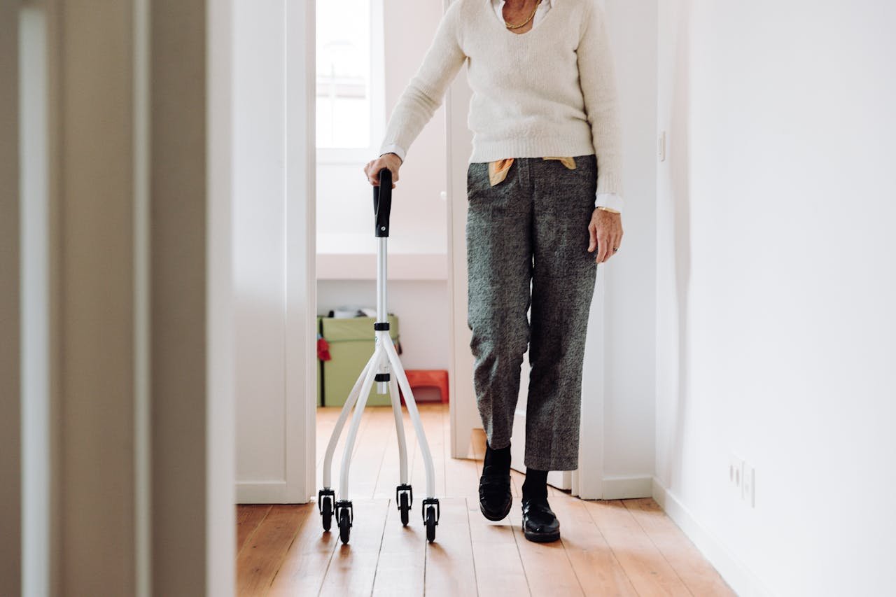 Senior adult walking indoors with a rollator, promoting mobility and independence.